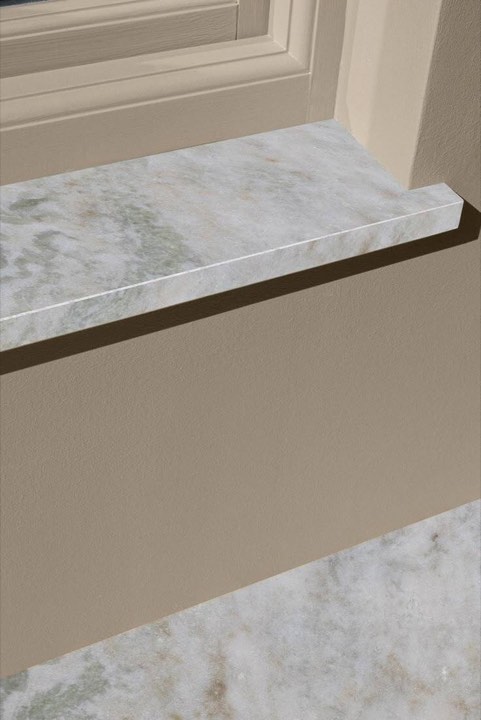 Подоконник из белого мрамора с прямой кромкой у окна, крупный план